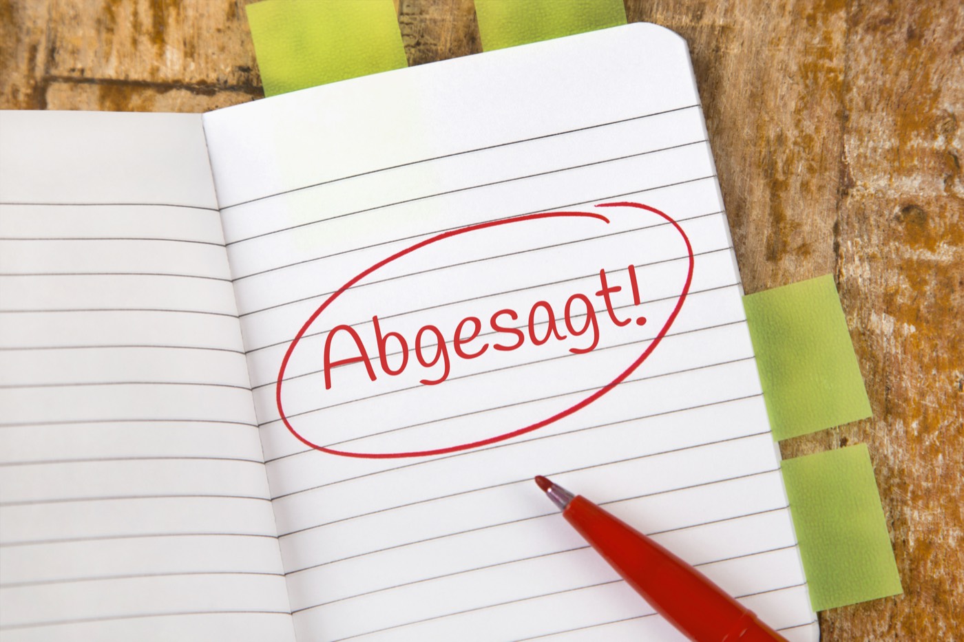 Notizbuch mit dem rot eingekreisten Wort „Abgesagt!“